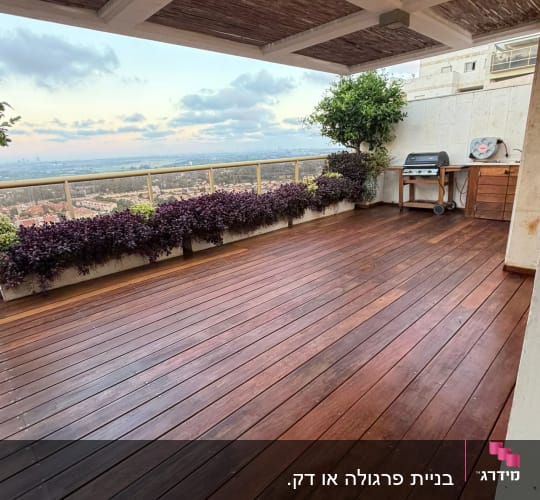 מרפסת עץ עם נוף לעיר וצמחייה
